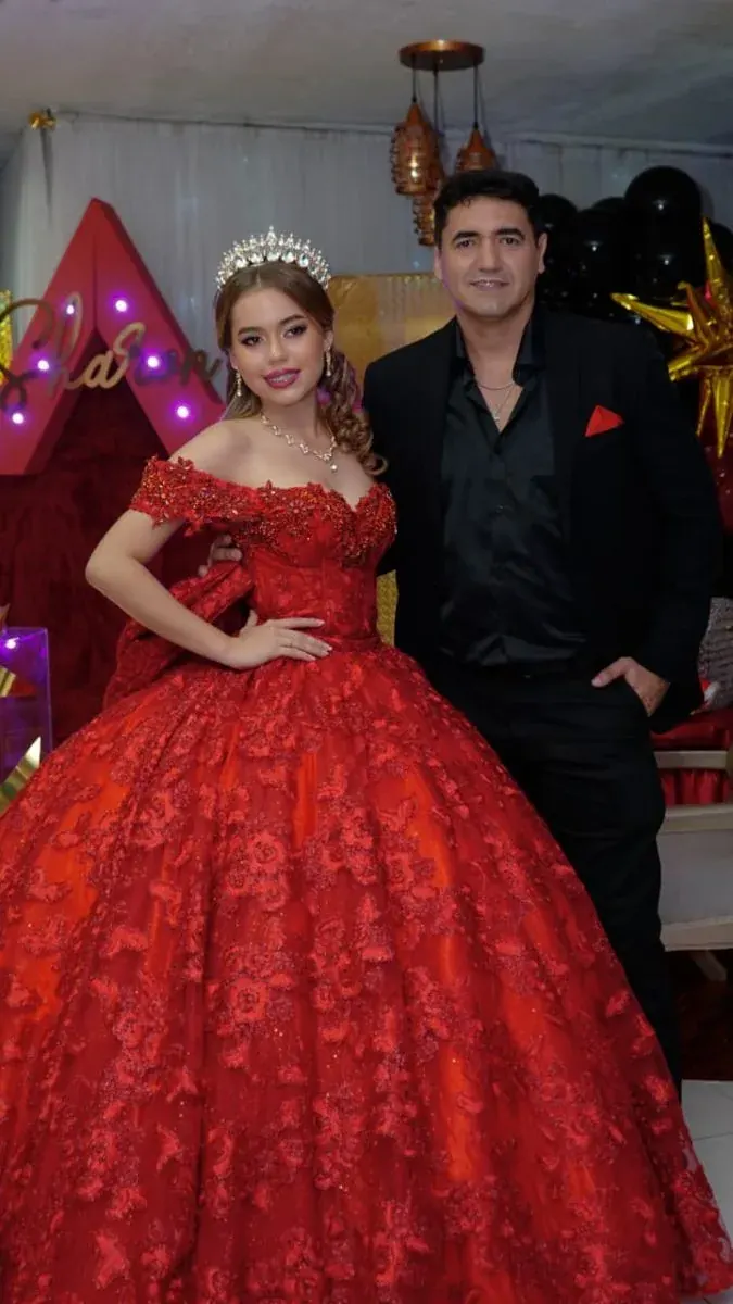 Retrato de quinceañera con vestido rojo junto a un invitado